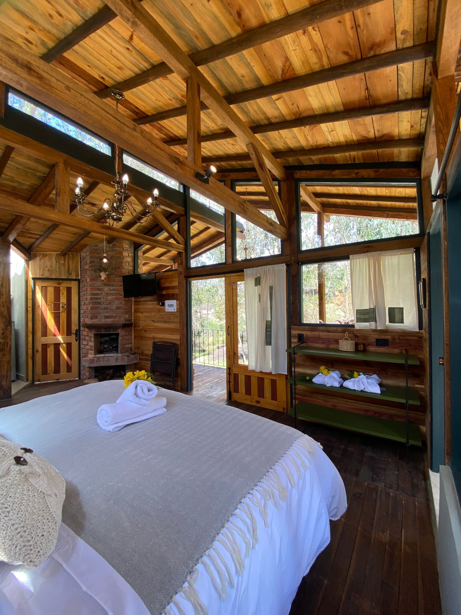 Habitación bajo la estructura de madera con ventanales en la parte alta