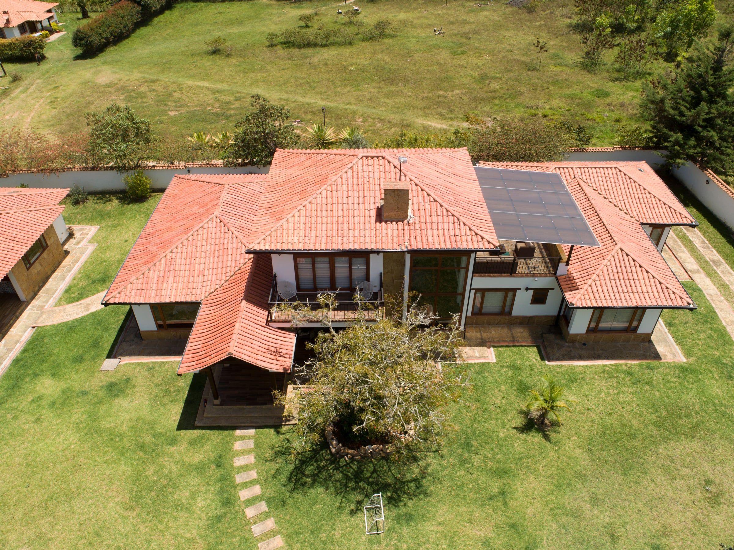 Vista aérea de la Casa Dividivi con sus cubiertas de teja de barro y el jardín que la rodea