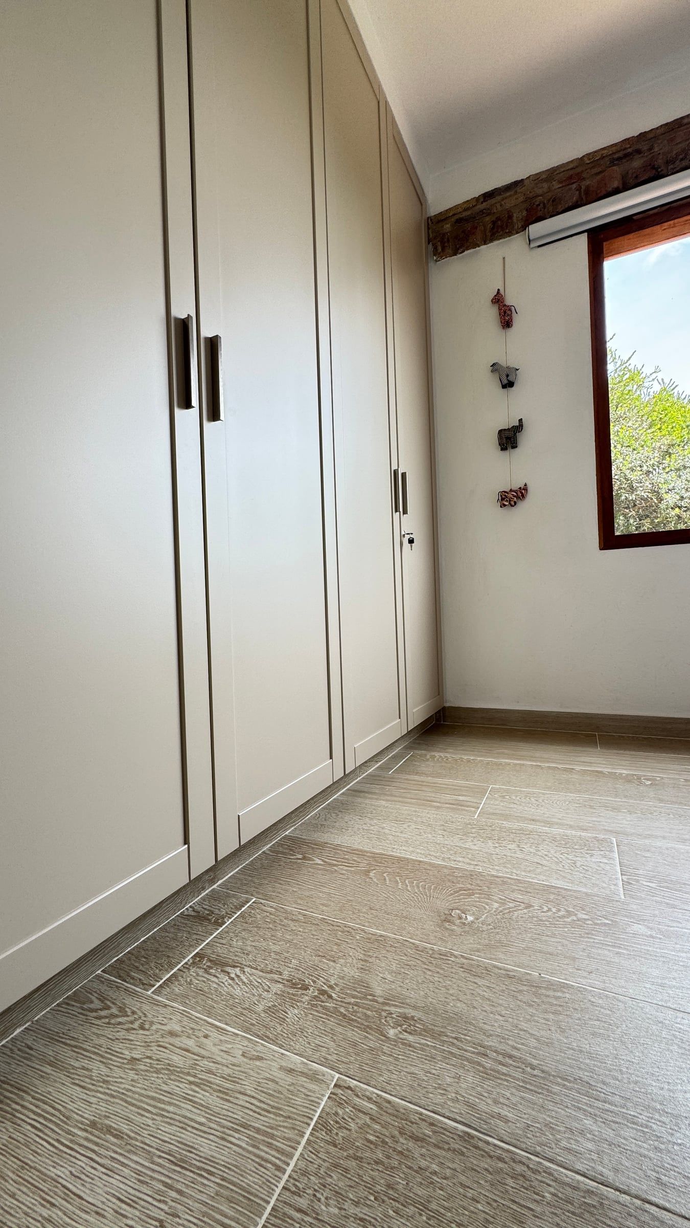 Casa Nido Verde después de la remodelación: clósets empotrados claros de piso a techo y piso tipo madera